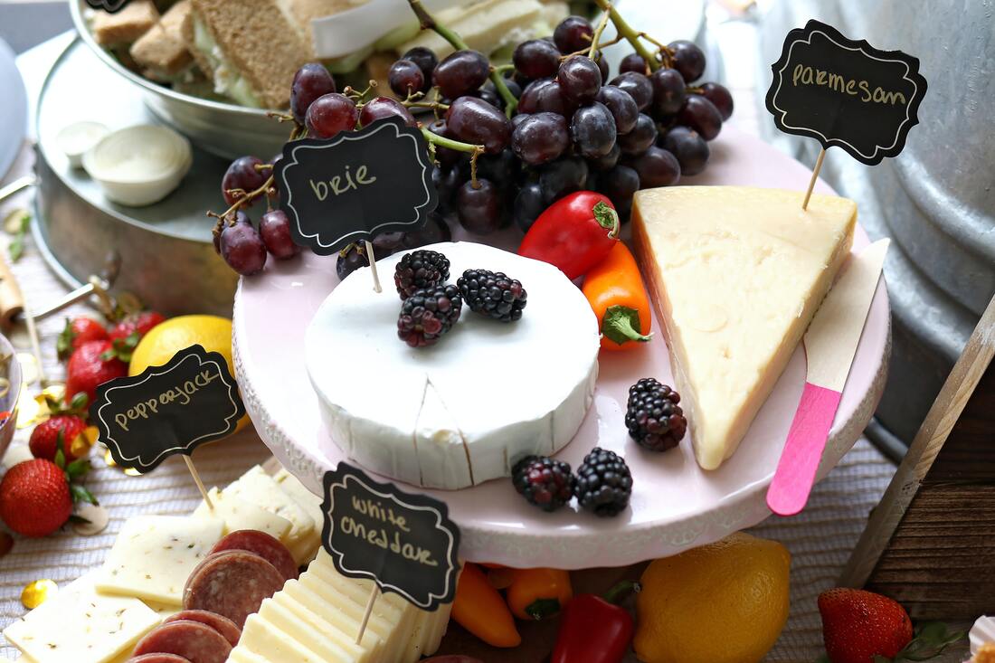 Beautiful table setting with premium cheeses displayed with scattered berries and fruits